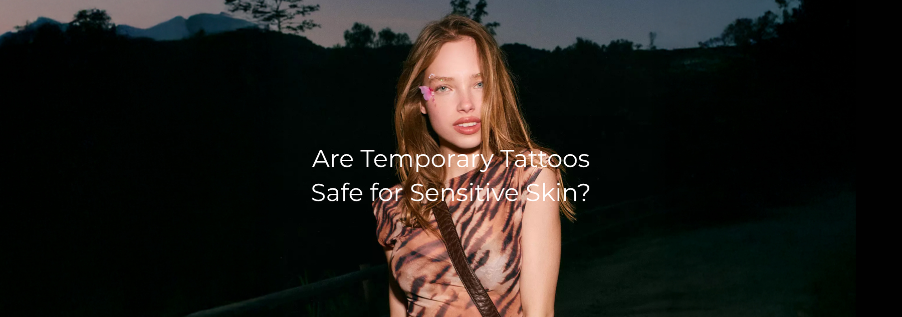 Woman with a face tattoo and text asking if temporary tattoos are safe for sensitive skin.
